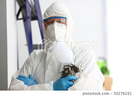 Workman hold in arm airbrush gun wearing protective suit 50276281