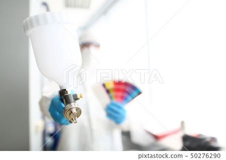 Hands of workman holding airbrush and colorful fantail picking wall 50276290