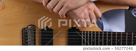 Male arms playing classic shape electric guitar 50277248