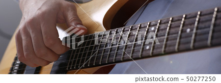 Male arms playing classic shape electric guitar 50277250