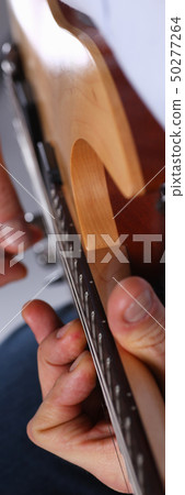 Male arms playing classic shape electric guitar 50277264