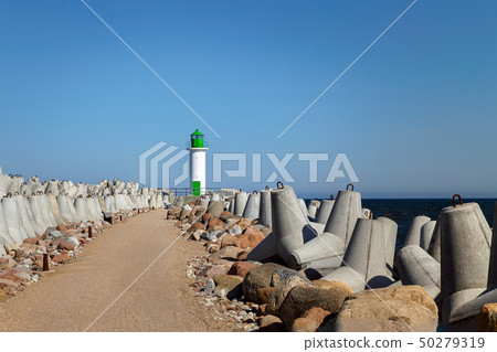 White lighthouse tower on blue sky background 50279319