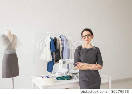 Dressmaker, fashion designer and tailor concept - Young dressmaker woman over clothes rack with 50279678