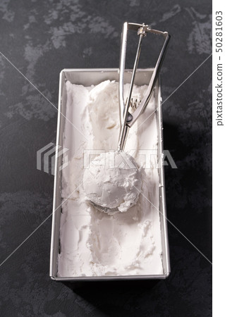 Vanilla ice cream scooped out of container, top 50281603