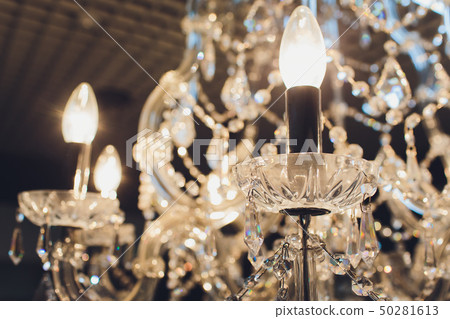 Close up on crystal of contemporary chandelier, is a branched ornamental light fixture designed to 50281613