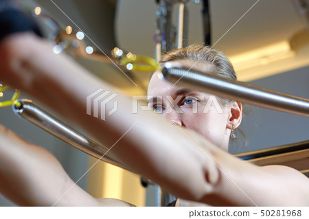 gym woman pilates stretching sport in reformer bed instructor girl. Selective focus on hands gym woman pilates stretching sport in reformer bed instructor girl. Selective focus on hands 50281968