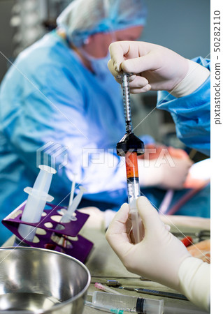 Hands Holding Syringe and Transfer Fat with Nano Fat Transfer Tool in Operation Room Hands Holding Syringe and Transfer Fat with Nano Fat Transfer Tool in Operation Room 50282110