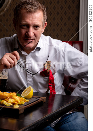 Fabulous at any age. Portrait of fashionable 50-year-old man in stylish siut posing at restaurant Fabulous at any age. Portrait of fashionable 50-year-old man in stylish siut posing at restaurant 50282192