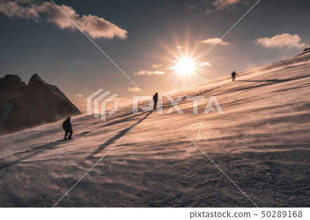 Mountaineers climbing in blizzard on snowy hill at 50289168