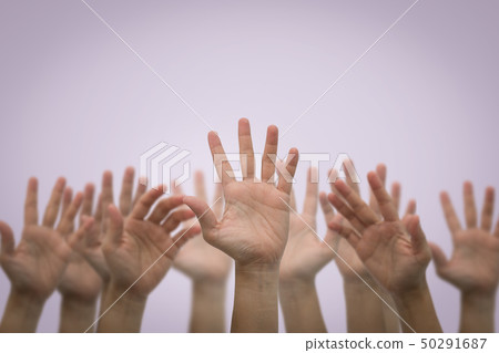 Group of human hands raised high up on pink 50291687