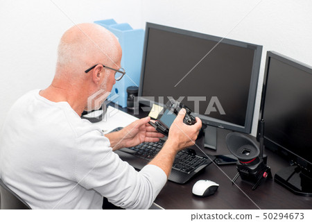mature photographer with camera at office with mature photographer with camera at office with 50294673