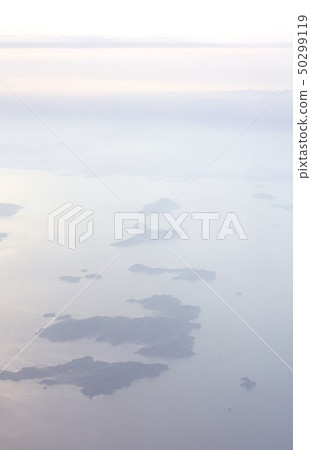 View Shiroishijima Island, Kitakijima Island, Manabejima Island, Sanagijima Island and Takamijima Island in the Seto Inland Sea, which floats in the morning from the sky over Fukuyama City 50299119