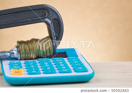 calculator and coins squeezed tightly in a G-Clamp calculator and coins squeezed tightly in a G-Clamp 50302883