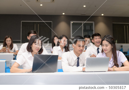 Group of students working with laptop in classroom 50305817