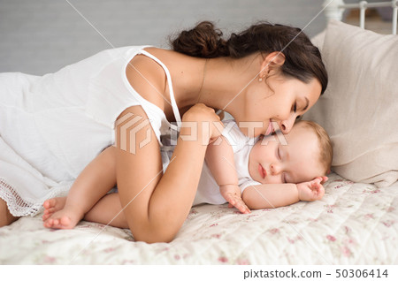Sweet baby boy sleeping in bed with his mother 50306414