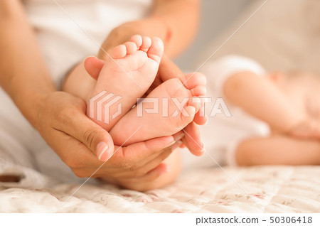 little baby feet in his mom's hands little baby feet in his mom's hands 50306418