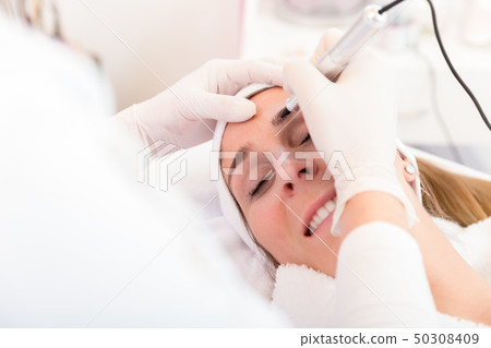 Attractive lady getting facial care and tattoo in salon Attractive lady getting facial care and tattoo in salon 50308409