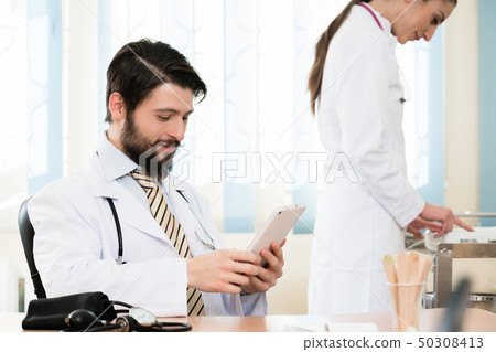 Doctor and his assistant in clinic 50308413