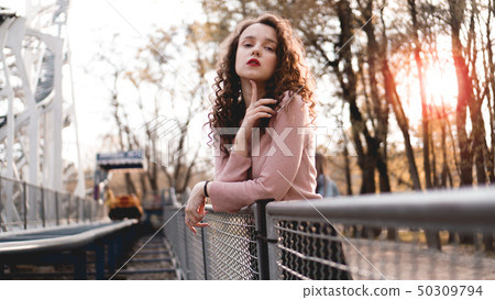 Closeup of a beautiful young woman with a sunset behind her Closeup of a beautiful young woman with a sunset behind her 50309794