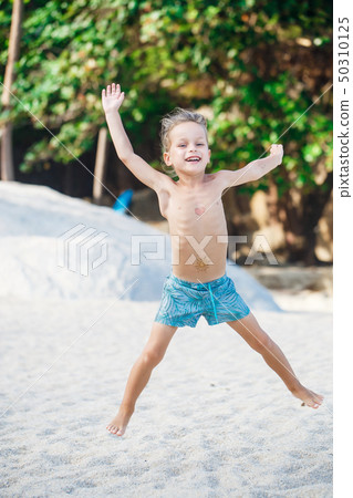 beautiful baby boy is having fun on the beach  50310125