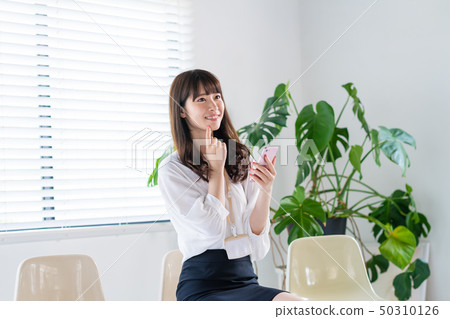 Young woman, smartphone, businesswoman, office casual 50310126