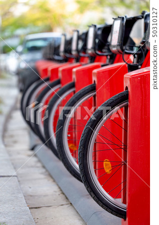 Bicycle rental station on city street. Public parking transportation 50310127