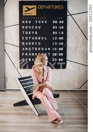 Fashionable lady in pink suit waiting for her Fashionable lady in pink suit waiting for her 50311701