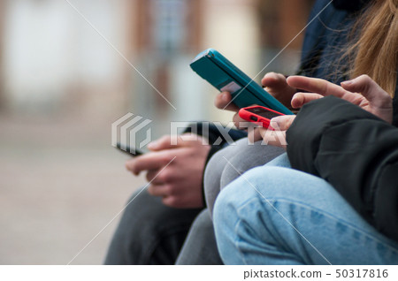 closeup of teenagers surfing on smartphone closeup of teenagers surfing on smartphone 50317816