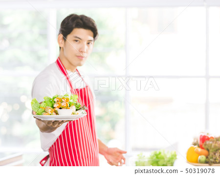Asian man held a salad plate for the camera.. 50319078