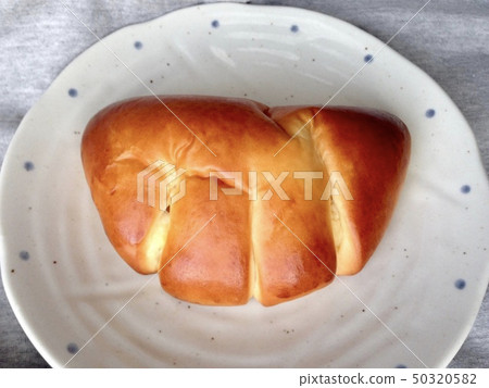 白盤子裡的一塊奶油麵包 白盤子裡的一塊奶油麵包 50320582