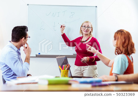 Delighted nice students pointing at the whiteboard 50323369
