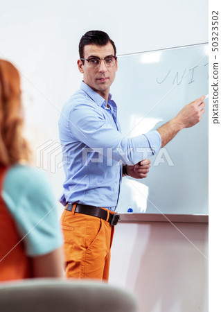 Smart young man explaining the rule near the whiteboard Smart young man explaining the rule near the whiteboard 50323502