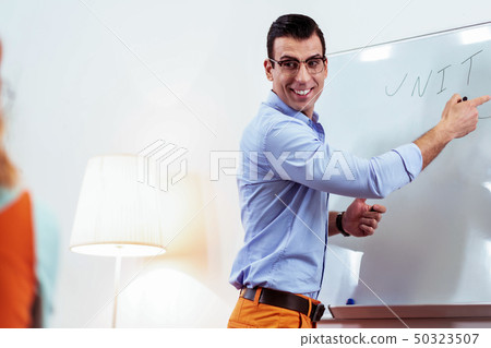 Joyful professional teacher smiling to his student 50323507