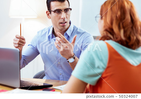 Intelligent young man sitting in front of the laptop Intelligent young man sitting in front of the laptop 50324007