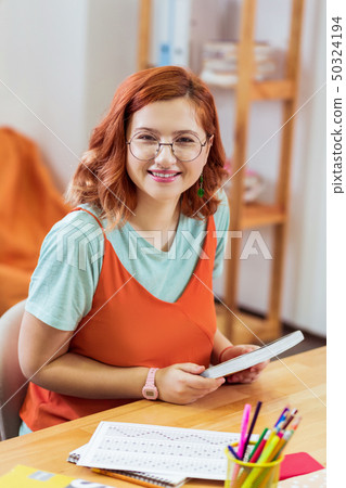 Delighted smart young woman holding her manuals 50324194