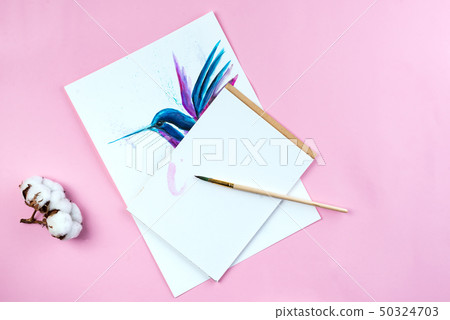 Top view of desktop workplace artist with tools - brushes, watercolor paint, notebook on pink 50324703