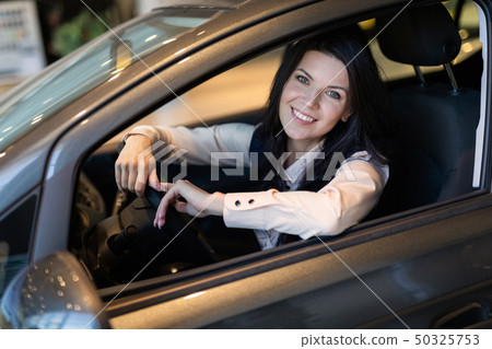 Happy customer woman buying a new car in dealeship center. Happy customer woman buying a new car in dealeship center. 50325753