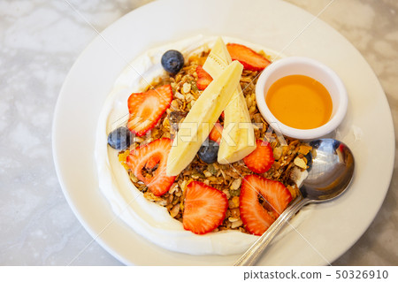 Homemade granola with yogurt and mixed fruits and honey from top view. 50326910