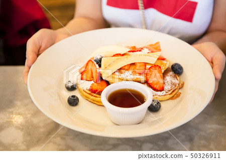 Woman hand holding breakfast meal of mixed fruits and maple syrup. 50326911