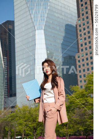 Lively business woman in a metropolitan building forest 50329799