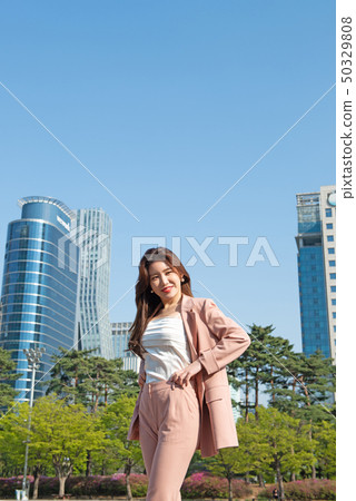 Lively business woman in a metropolitan building forest Lively business woman in a metropolitan building forest 50329808