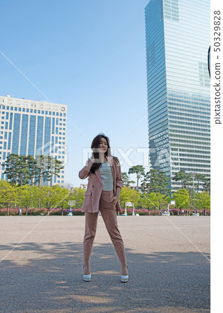 Lively business woman in a metropolitan building forest 50329828