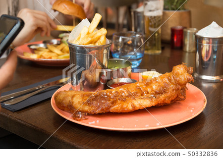 British Traditional Fish and chips with mashed peas on the table. British Traditional Fish and chips with mashed peas on the table. 50332836
