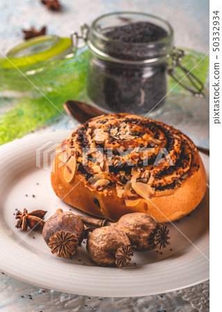 Few poppy heads on white plate with sweet baked 50332934