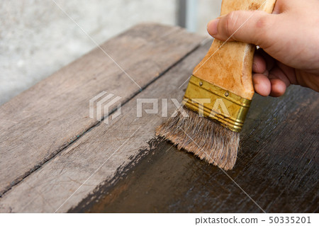 hand holding a brush Painting wooden timber boards hand holding a brush Painting wooden timber boards 50335201