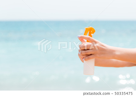 Young woman with sun protection spray for body at Young woman with sun protection spray for body at 50335475
