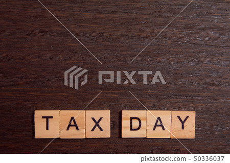 Tax day with wooden alphabet blocks on dark plank 50336037
