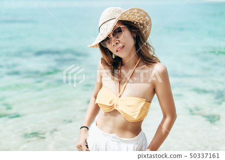 Cheerful girl wears bikini and white hat posing Cheerful girl wears bikini and white hat posing 50337161