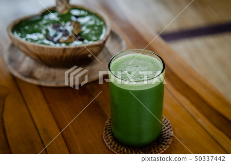 Glass of green celery juice on wooden table Glass of green celery juice on wooden table 50337442