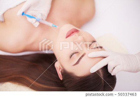 Injection And Woman Beauty Face. Attractive girl with perfect skin. Woman in spa ,massage the back 50337463